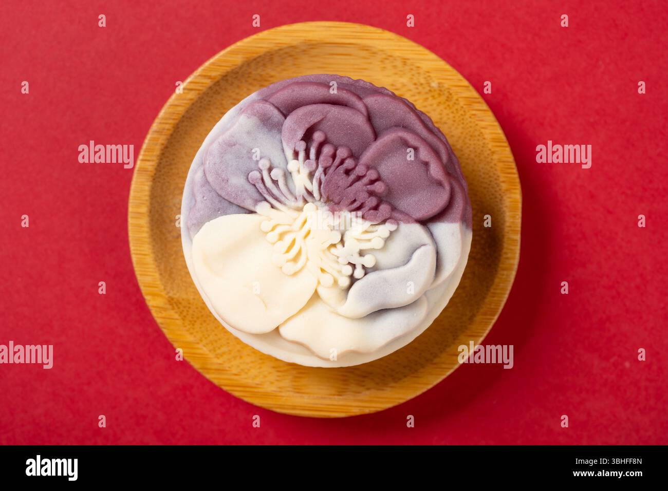vue de dessus forme de fleur blanc et violet mooncake sur rouge Banque D'Images