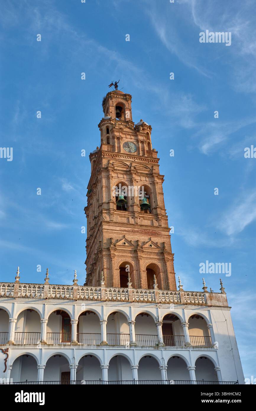Le clocher baroque de l'église notre-Dame de Grenade s'élève splendide au-dessus de la galerie des arches blanchies à la chaux de la Plaza de España à Llerena Banque D'Images