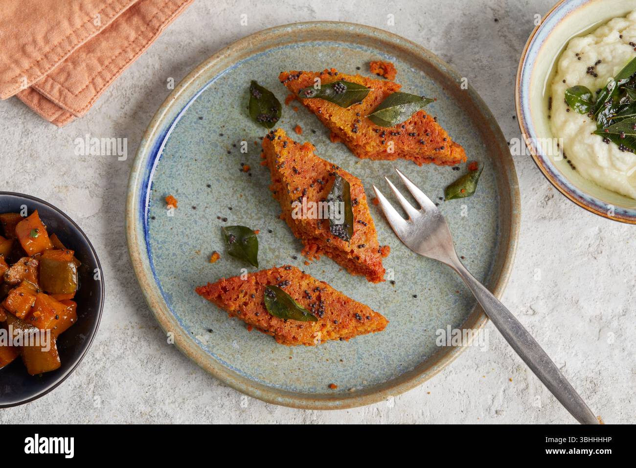 Gâteau aux pois chiches Dhokla sur une assiette – une collation indienne moelleuse et épicée à base de farine de pois chiches fermentée, parfaite pour le déjeuner végétalien Banque D'Images