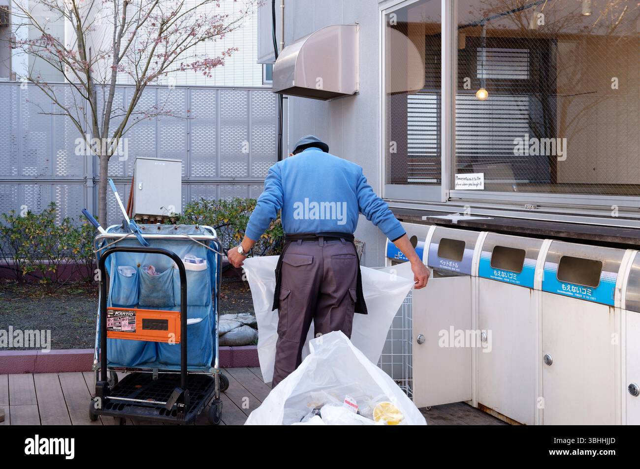 Travailleur trie les déchets en dehors d'un marché alimentaire de Tokyo Banque D'Images