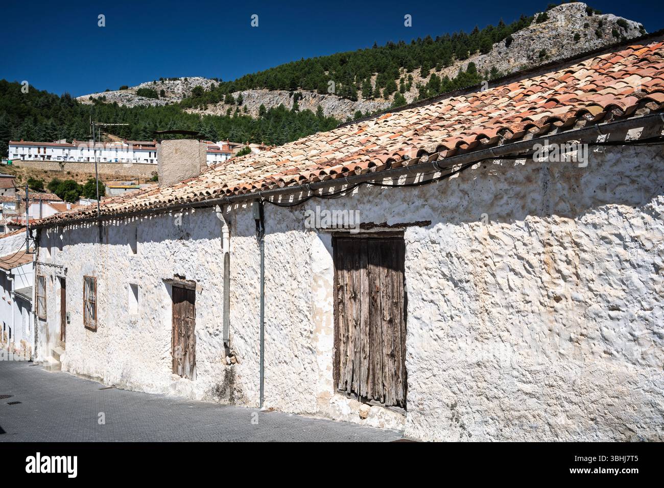 Promenez-vous dans les rues étroites de Santiago de la Espada, admirez les façades blanchies à la chaux et l'architecture traditionnelle sous un ciel dégagé. Banque D'Images