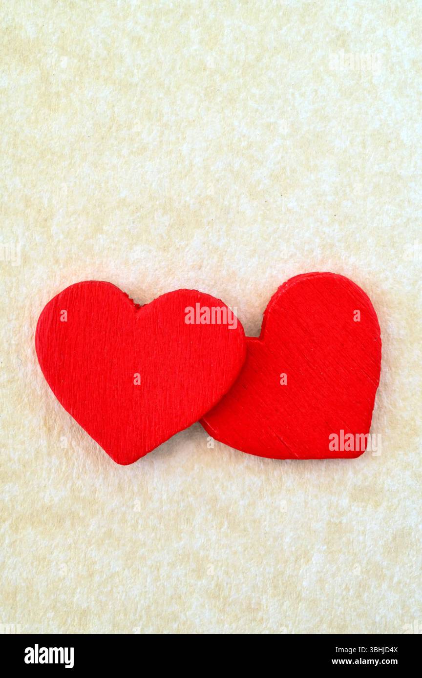 Deux formes de coeur en bois rouge écarlate sur fond Uni Banque D'Images Deux formes de coeur en bois rouge écarlate sur fond Uni Banque D'Images