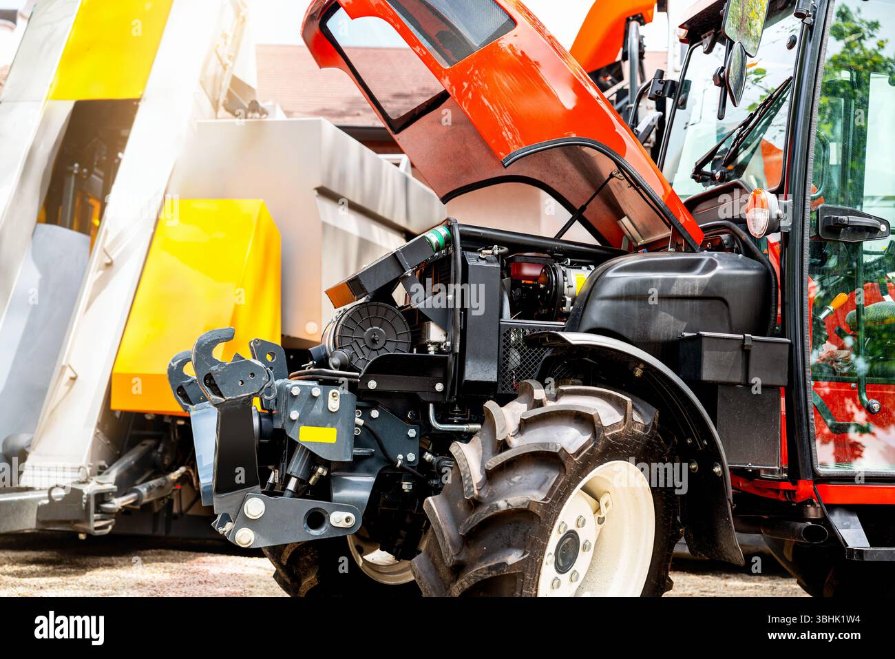 Scène de réparation d'équipement agricole avec capot de tracteur ouvert sur les terres agricoles Banque D'Images