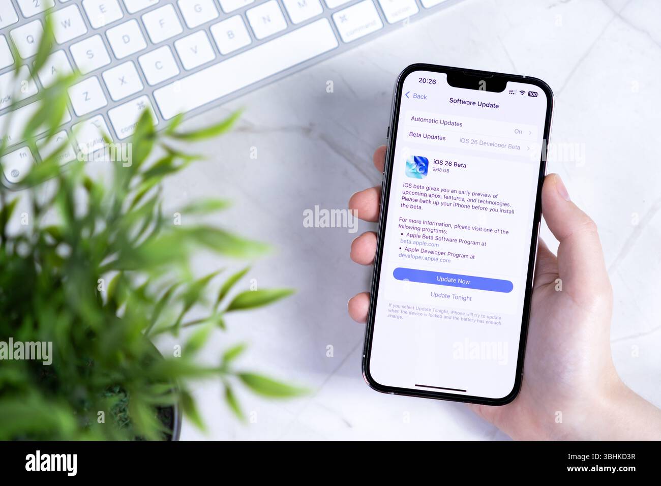 Poznan, Pologne - 10 juin 2025 : gros plan détaillé d'un smartphone élégant tenant à la main affichant la nouvelle mise à jour logicielle iOS 26 Beta, mettant l'accent sur l'innovation Banque D'Images