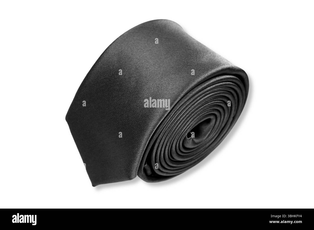 Une cravate noire roulée sur fond blanc vue gros plan espace de copie Banque D'Images