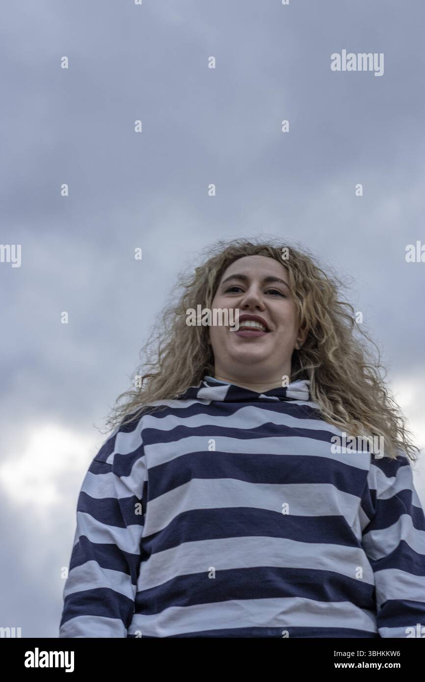 Portrait de mode de style de vie en plein air de la fille blonde étonnante heureuse. Beau sourire. Cheveux longs bouclés et clairs. Bonheur Banque D'Images