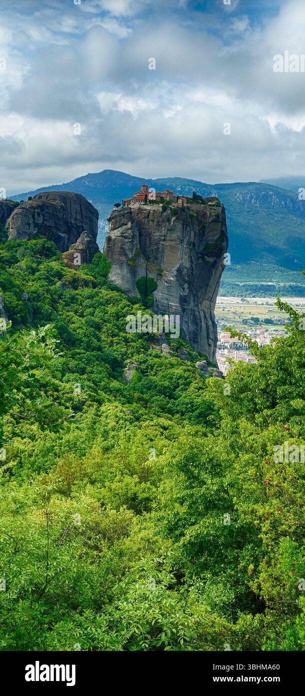 METERORA, GFEECE - 11 MAI 2025 - Monastère de pierre perché sur une falaise abrupte, paysage verdoyant encadrant un pinacle rocheux Banque D'Images
