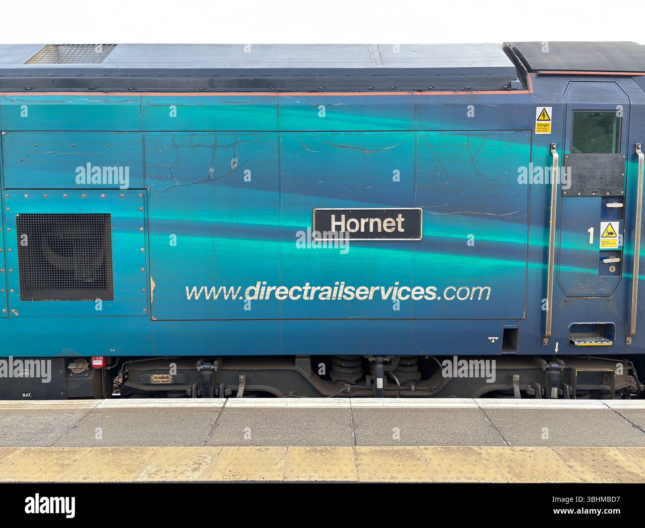 Un train de marchandises passe devant la gare d'Aviemore, transportant des marchandises à travers les Highlands, illustrant le transport rural vital et l'industrie. Banque D'Images