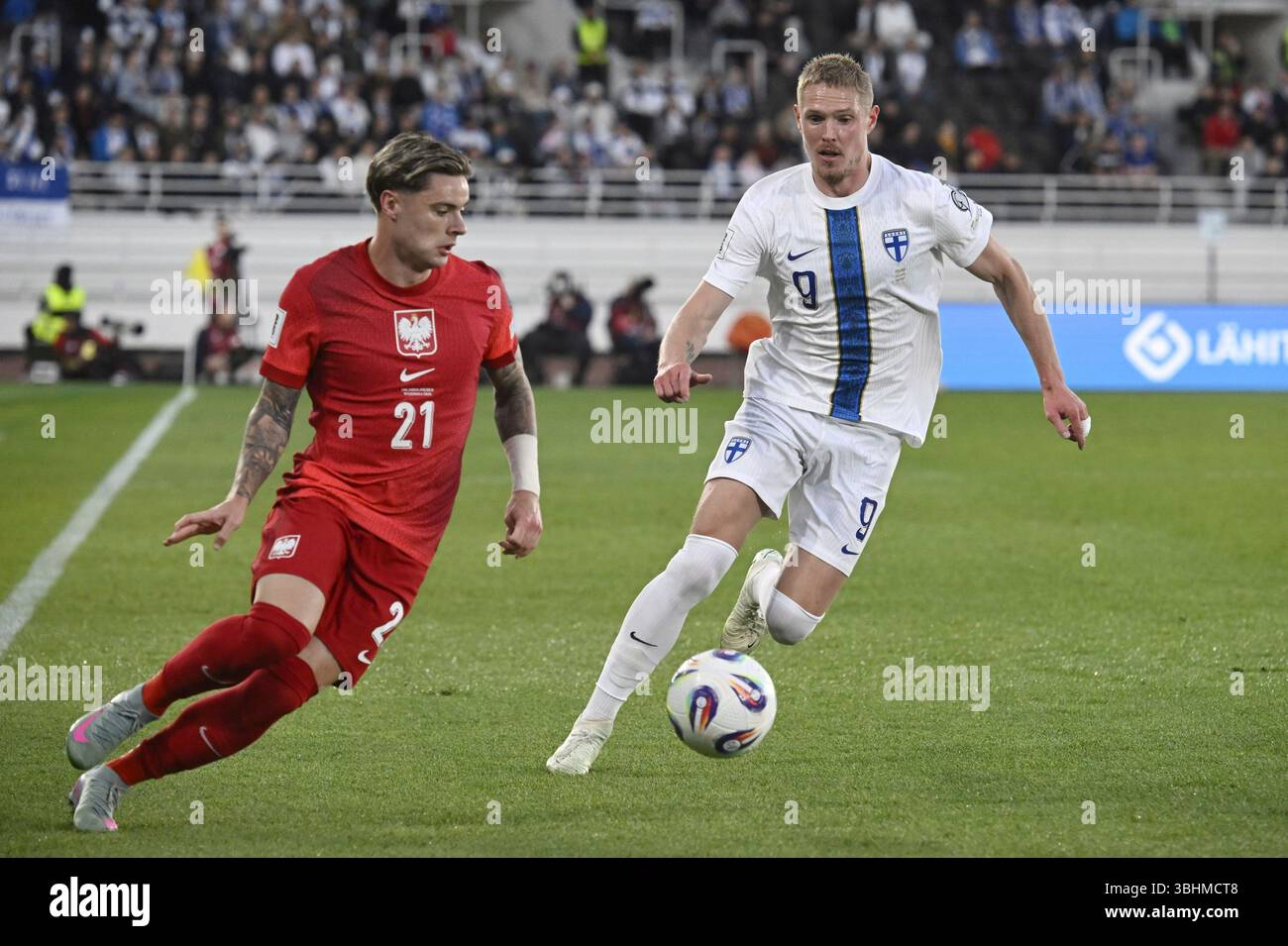 Poland's Nicola Zalewski (21) dribbles ahead of Finland's Fredrik Jensen during a 2026 FIFA World Cup qualifying Group G soccer match between Finland and Poland at the Olympic Stadium in Helsinki, Finland, Tuesday, June 10, 2025. (Markku Ulander/Lehtikuva via AP) Banque D'Images