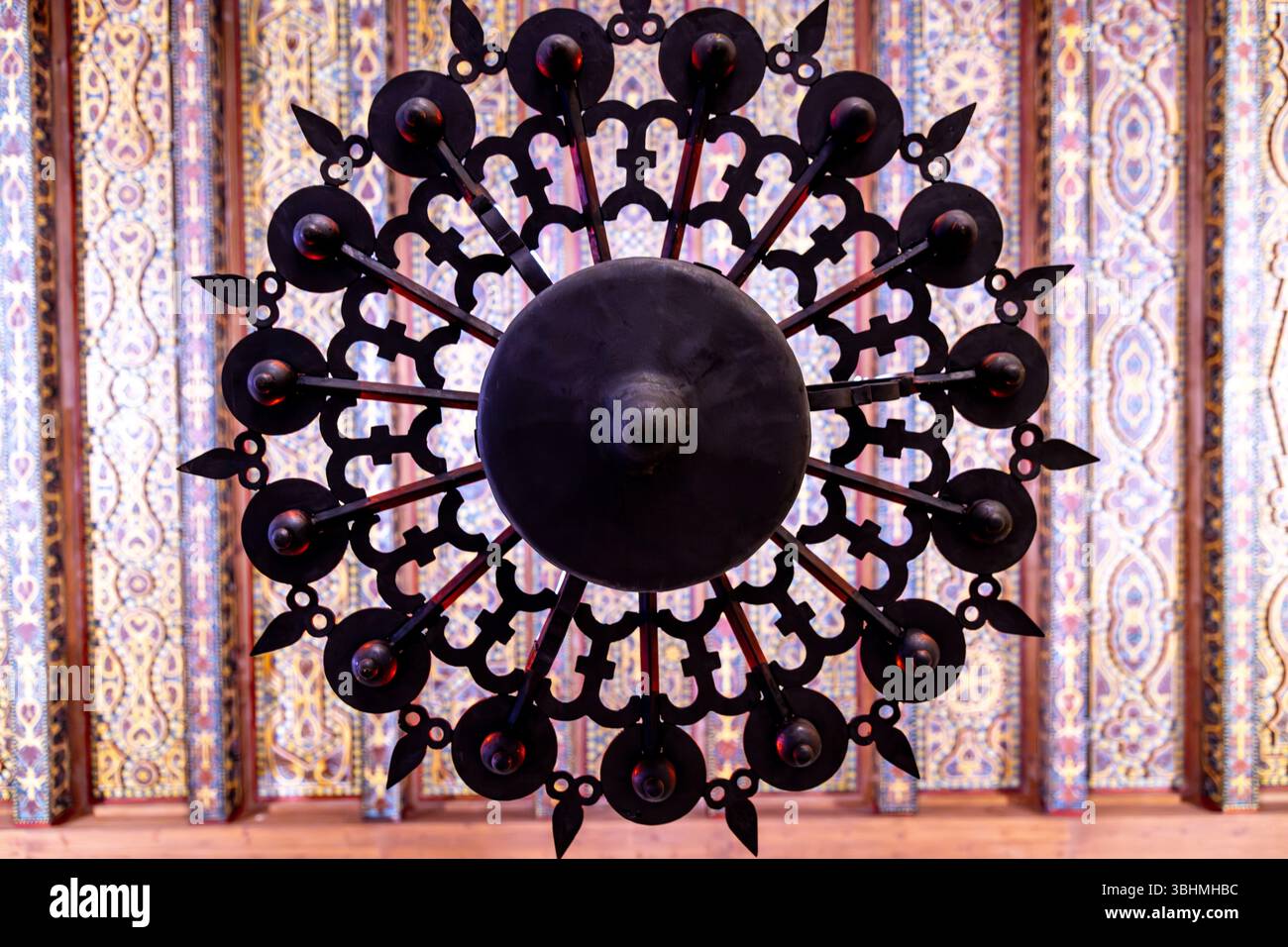 Cordoue, Cordoue - Espagne - 04-08-2024 : un lustre noir orné avec des ferronneries complexes, posé contre un plafond à motifs dans la Mezquita-Catedral d Banque D'Images