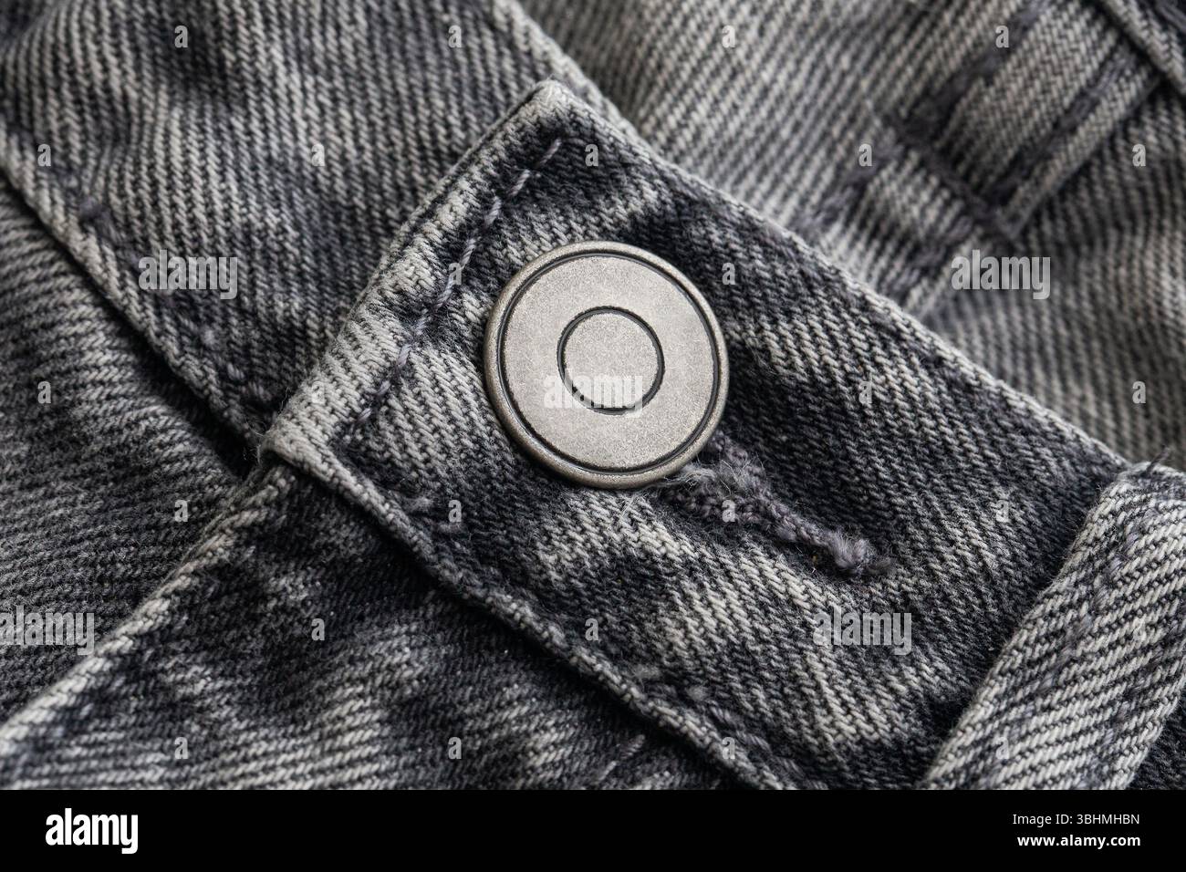 Vue rapprochée du pantalon en denim noir. Bouton en métal sur un Jean. Texture de tissu solide. Élégant détail vêtements décontracté. Matériau mode rugueux et robuste. Banque D'Images