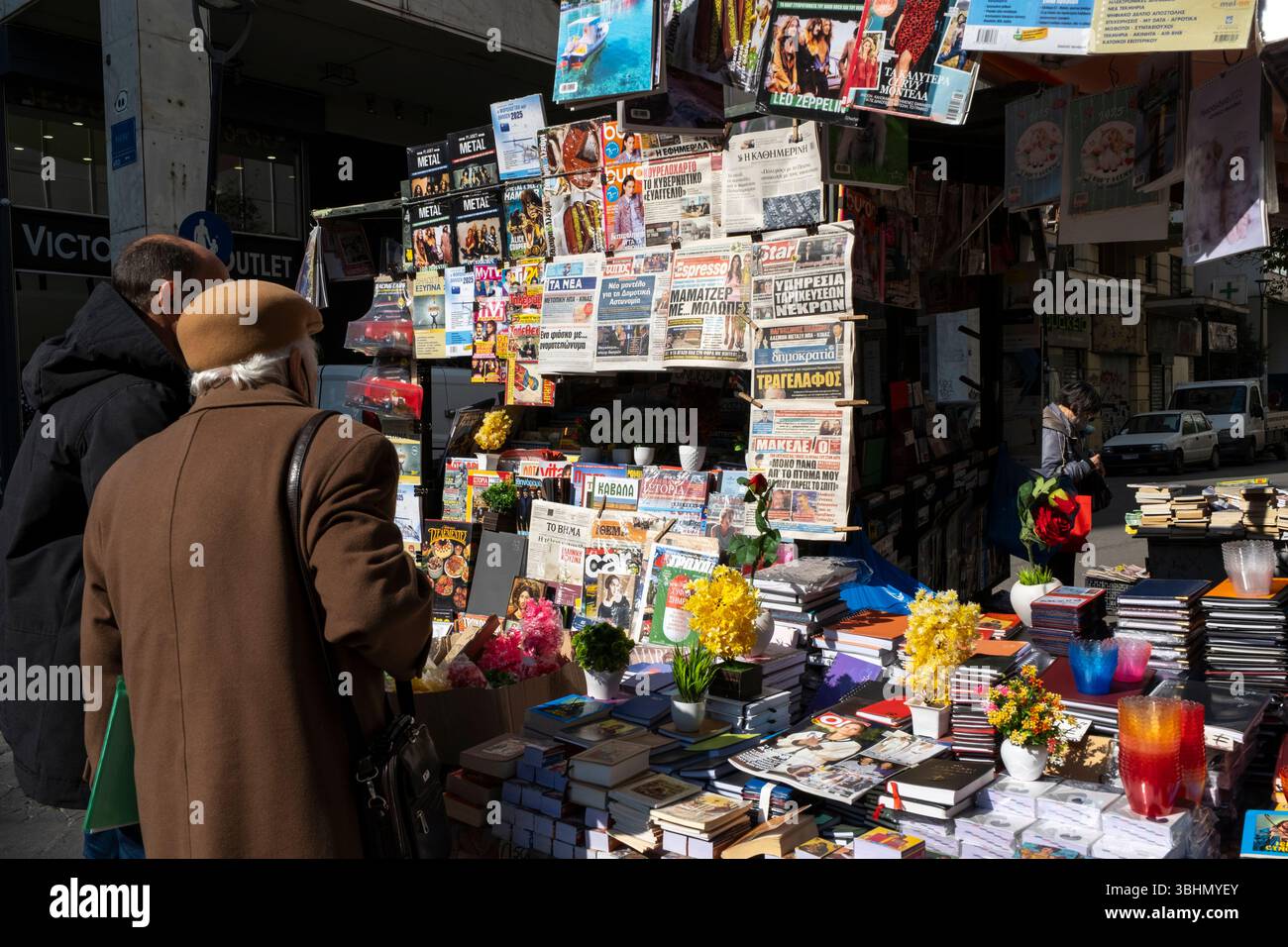 Acheteurs à un kiosque de journaux et de livres dans le quartier commerçant de Plaka, au centre d'Athènes, Grèce. Banque D'Images
