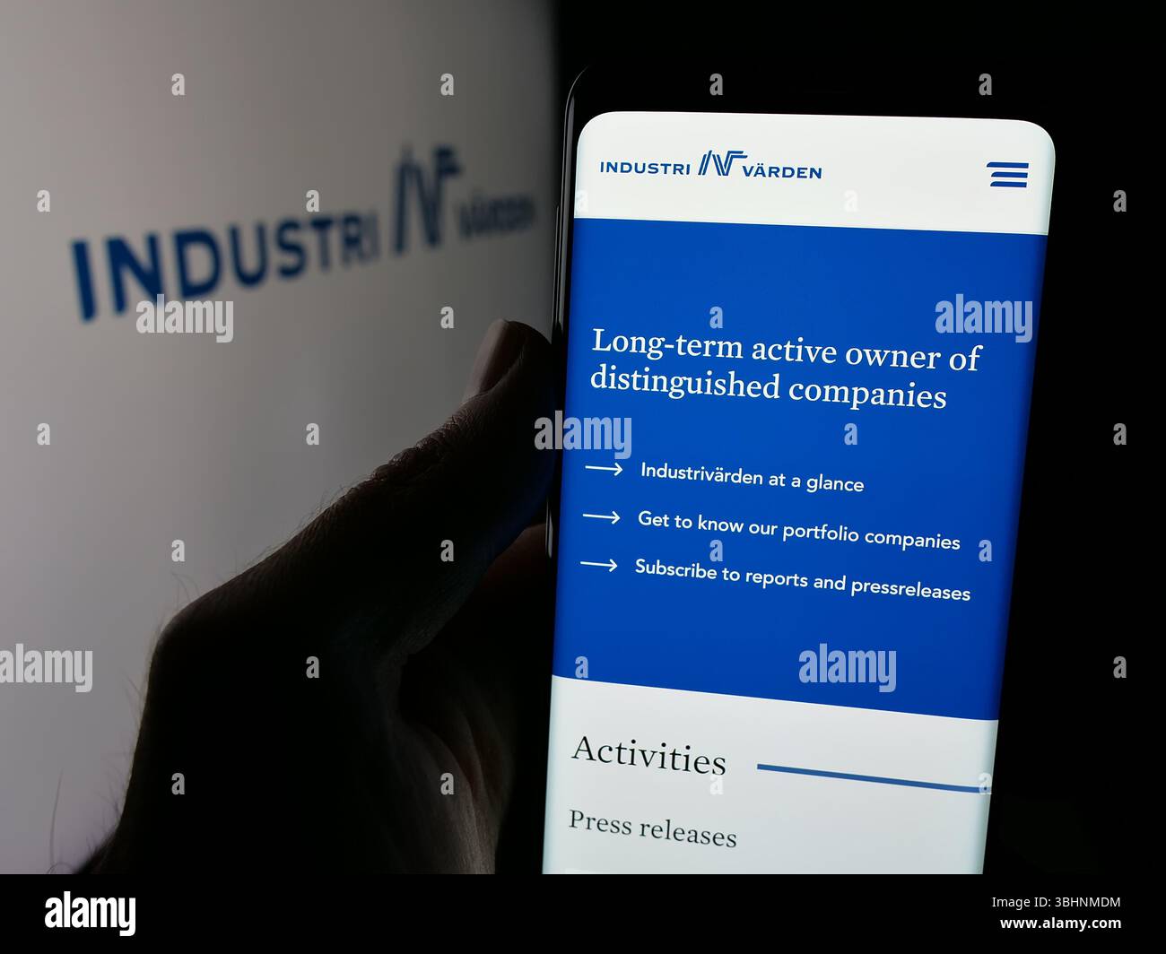 Stuttgart, Allemagne - 03-13-2025 : personne tenant un téléphone portable avec la page web de la société d'investissement suédoise Industrivärden AB sur l'écran devant le logo. Banque D'Images