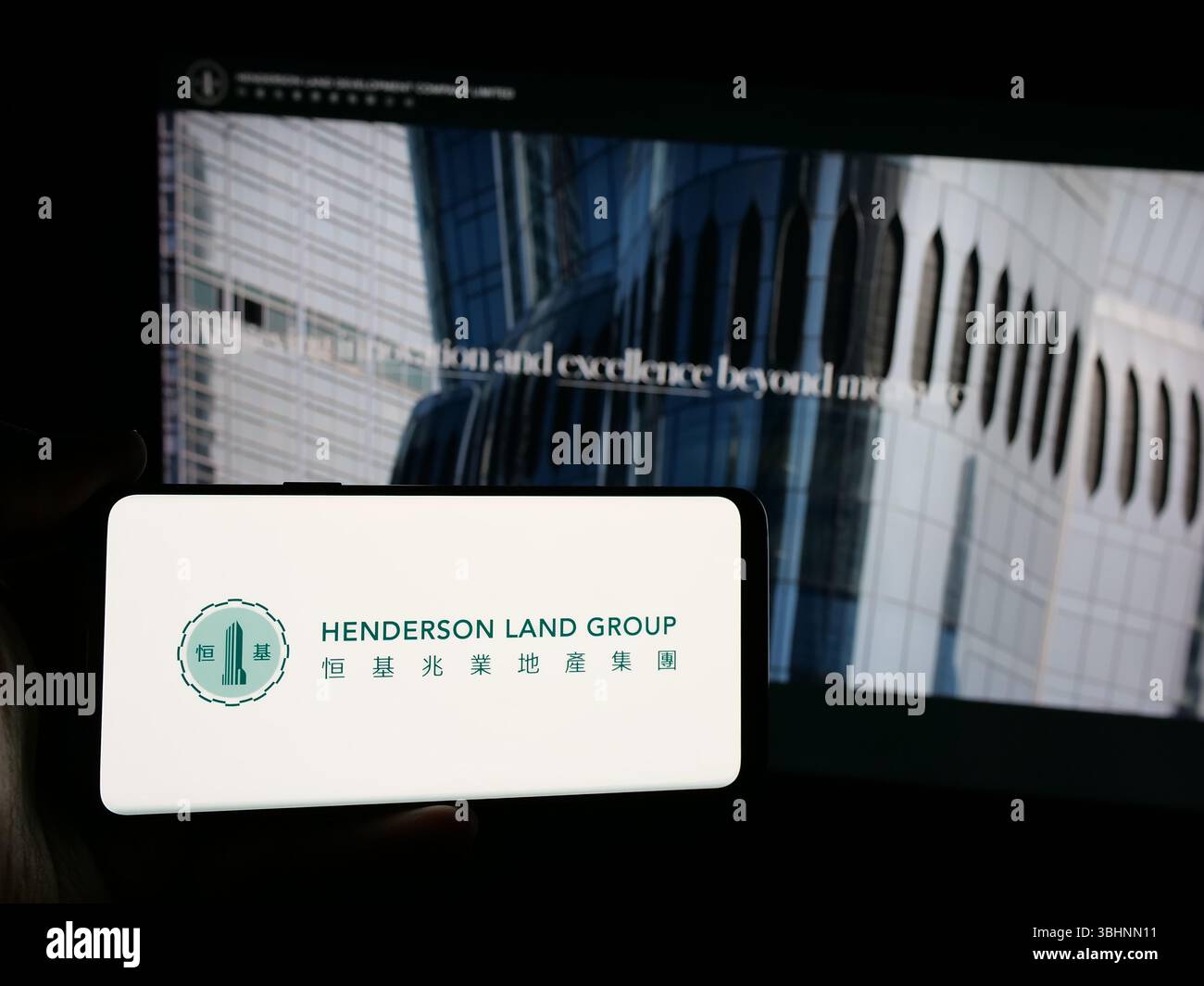 Stuttgart, Allemagne - 03-14-2025 : personne tenant un smartphone avec le logo de la société Henderson Land Development Co. Ltd. sur l'écran en face du site Web. Banque D'Images Stuttgart, Allemagne - 03-14-2025 : personne tenant un smartphone avec le logo de la société Henderson Land Development Co. Ltd. sur l'écran en face du site Web. Banque D'Images