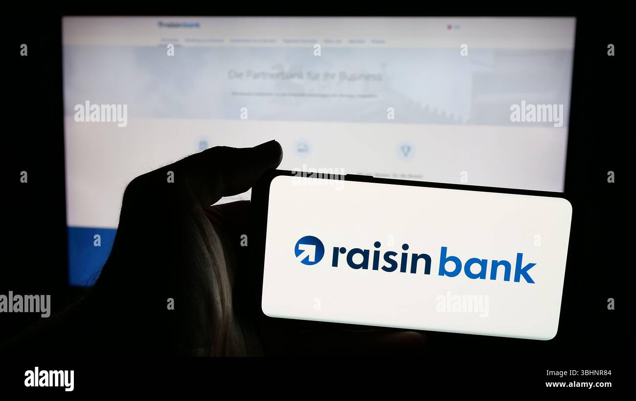 Stuttgart, Allemagne - 03-20-03 2025 : personne tenant un téléphone portable avec le logo de la société financière allemande raisin Bank AG sur l'écran en face de la page Web. Banque D'Images
