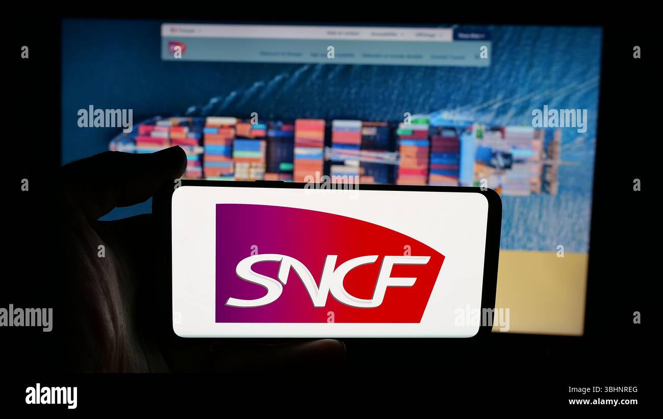 Stuttgart, Allemagne - 03-20-03 2025 : personne tenant un téléphone portable avec le logo de la compagnie ferroviaire française SNCF Group sur l'écran en face de la page web. Banque D'Images