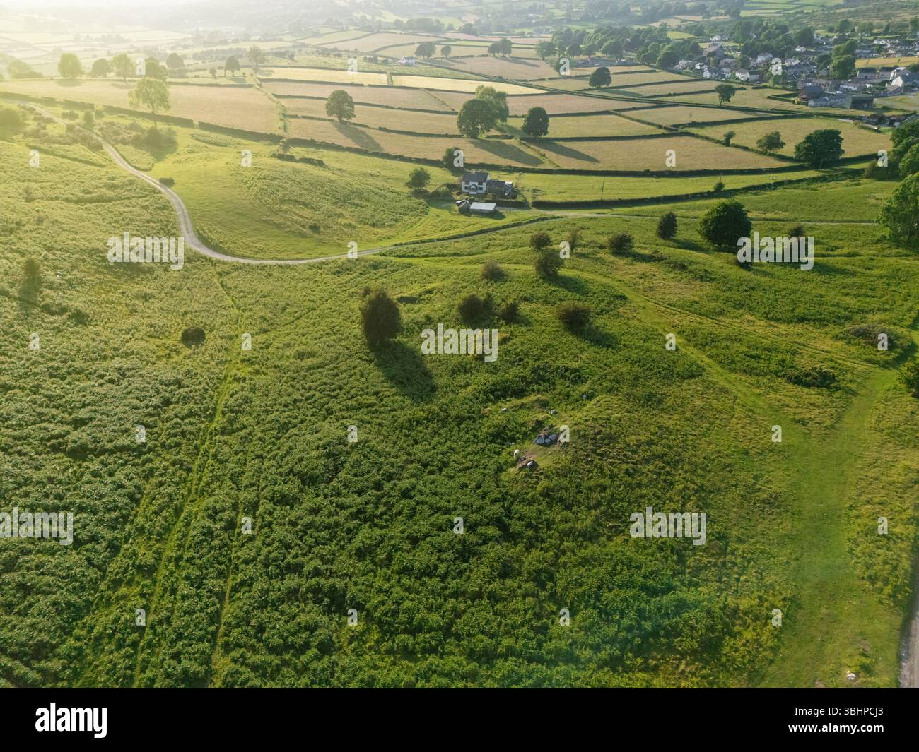 Vue aérienne de la campagne vallonnée près du village de Moel-y-crio dans le nord du pays de Galles alors que le soleil commence à descendre bas dans le ciel, Royaume-Uni Banque D'Images