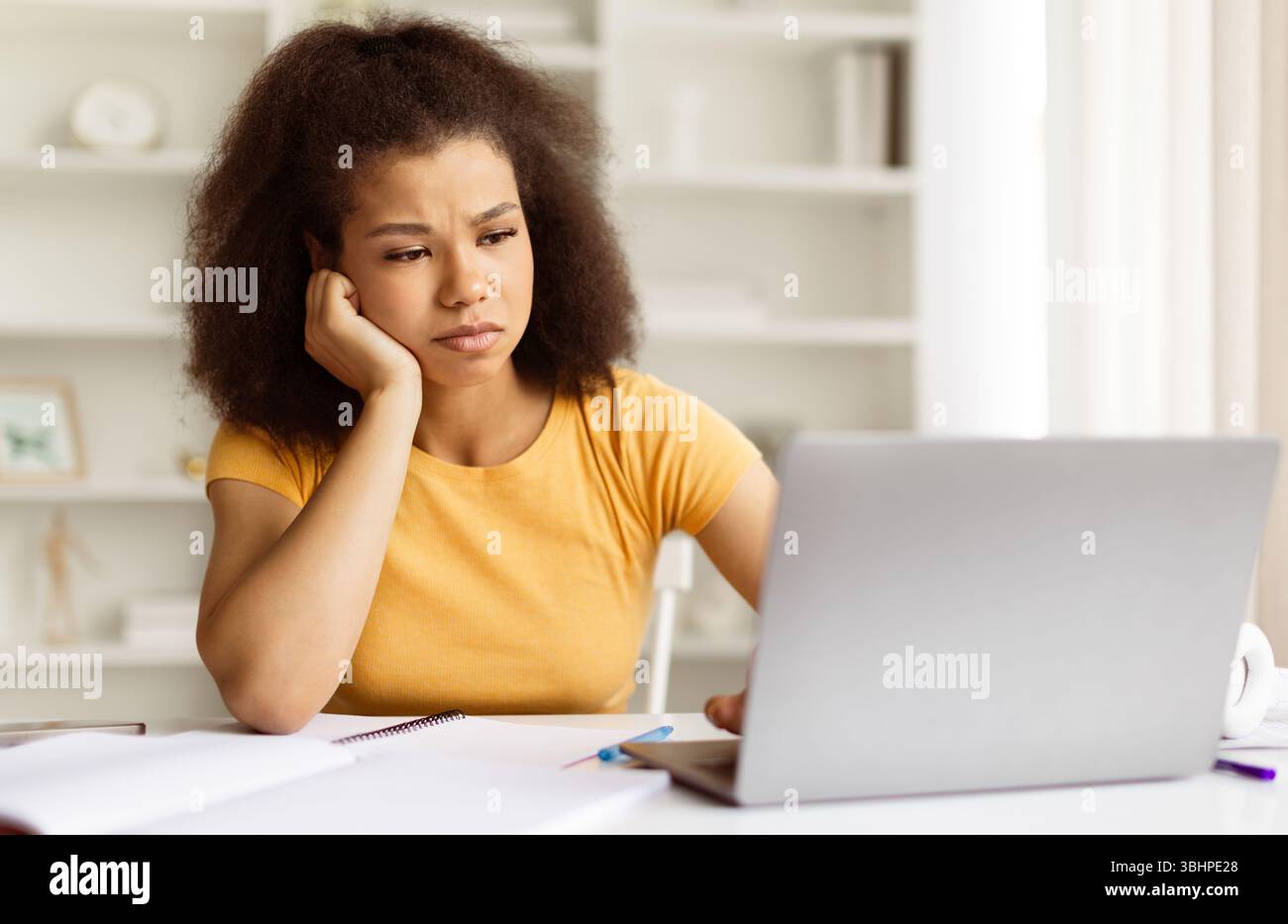Étudiante afro-américaine fatiguée ou frustrée regardant mécontente de son ordinateur portable Banque D'Images