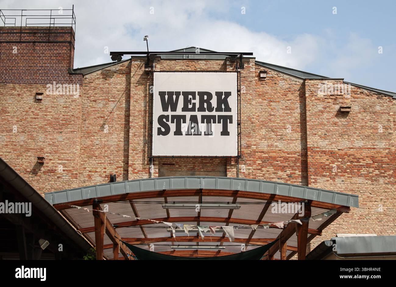 Berlin, Allemagne. 11 juin 2025. Un panneau portant les mots « Werkstatt » (atelier) est accroché sur la façade d'un bâtiment. Dans le cadre des mesures de réduction des coûts dans le secteur culturel, le gouvernement de l'État de Berlin envisage de dissoudre les ateliers de théâtre de la Volksbühne am Rosa-Luxemburg-Platz et de les transférer à la Bühnenservice Berlin en termes d'espace et de personnel. Crédit : Hannes Albert/dpa/Alamy Live News Banque D'Images