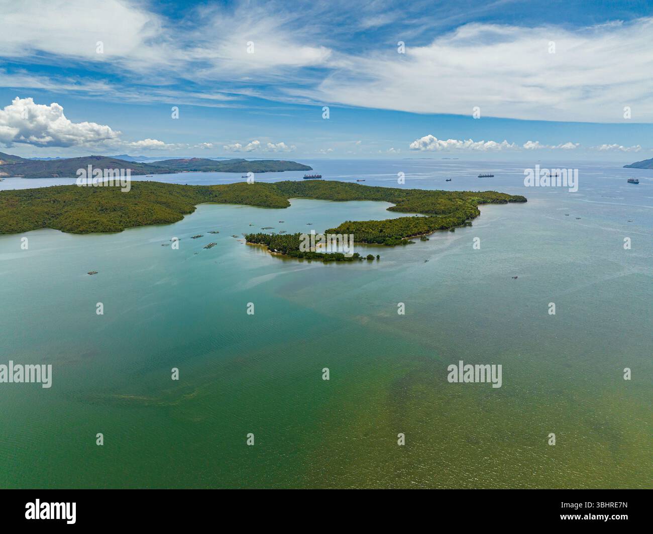 Baie maritime de l'île tropicale avec cargo et navire marchand. Ciel bleu et nuages. Mindanao, Philippines. Banque D'Images