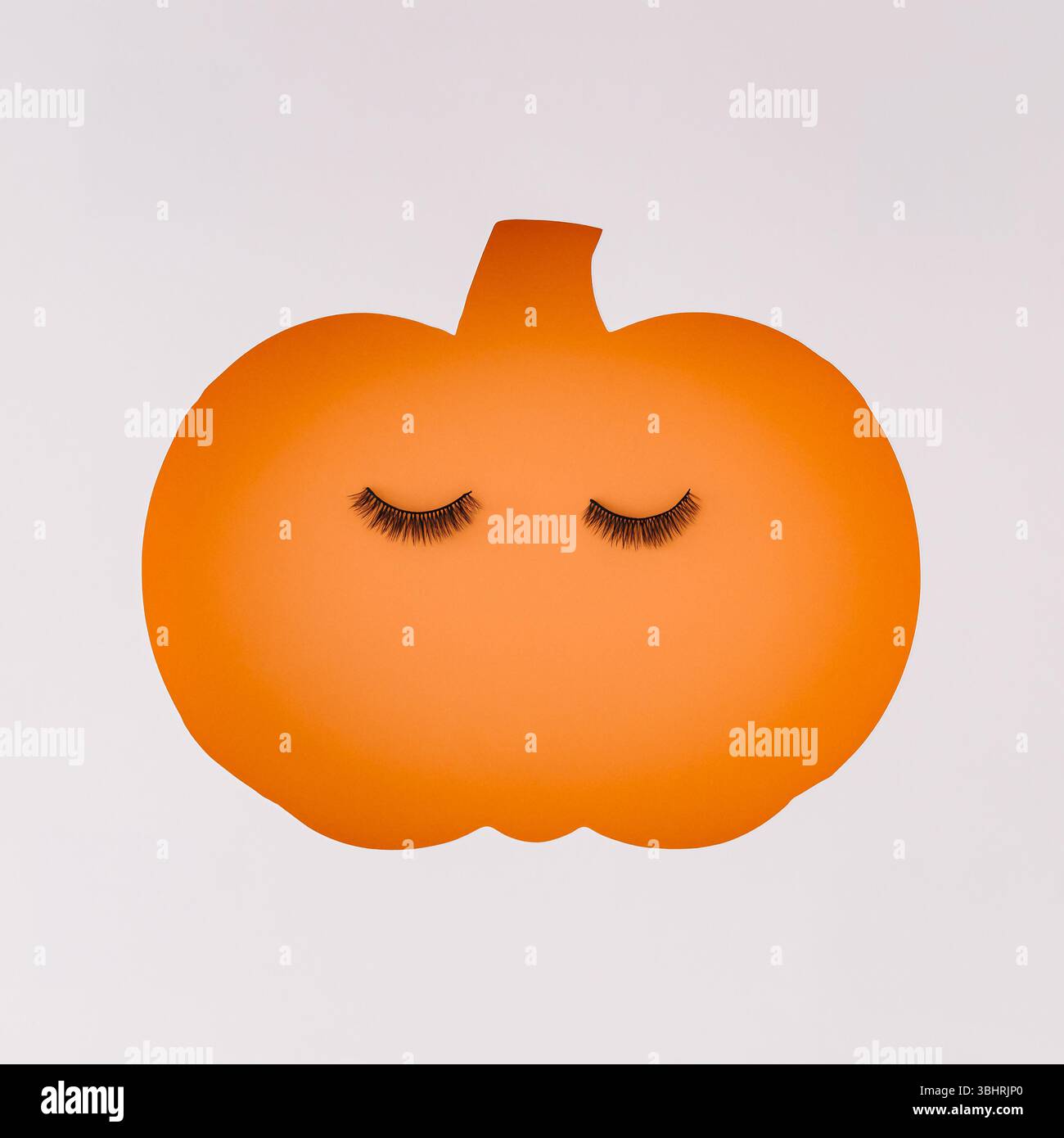 Découpe de citrouille d'automne avec faux cils. Concept de beauté d'automne minimal. Beauté et maquillage créatifs saisonniers Esthétique tendance de l'automne. style de pose à plat Banque D'Images