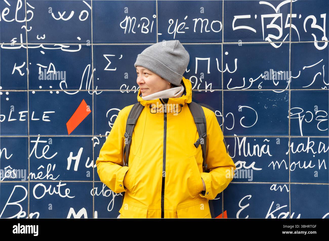 Paris, France - 28 février 2025 : une touriste souriante devant le mur des amoureux (le mur des je taime) à Montmartre, Paris. Le vibran Banque D'Images