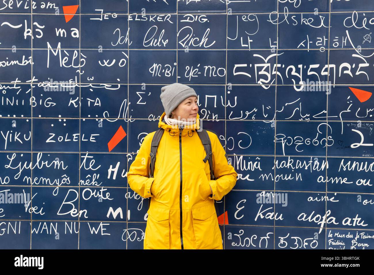 Paris, France - 28 février 2025 : une touriste souriante devant le mur des amoureux (le mur des je taime) à Montmartre, Paris. Le vibran Banque D'Images