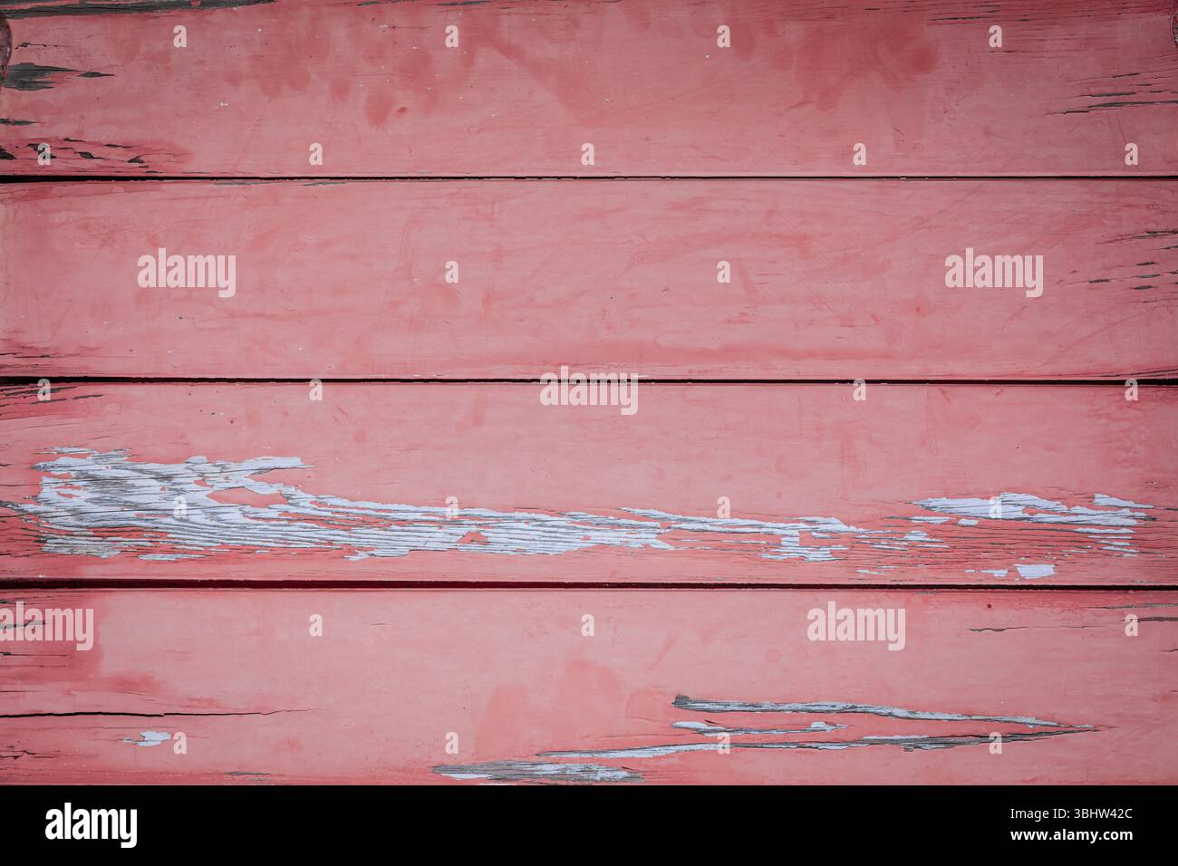 Vue de haut en bas de la vieille table en bois avec peinture rouge clair pelable, plusieurs planches, surface texturée Banque D'Images