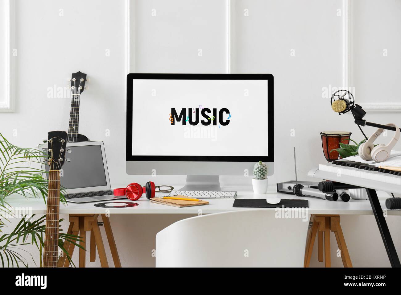 Lieu de travail avec ordinateur et instruments de musique près du mur de lumière dans le studio Banque D'Images