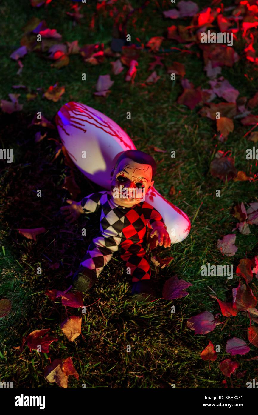 Configuration d'accessoires d'Halloween avec poupée de clown et arme tachée de sang Banque D'Images