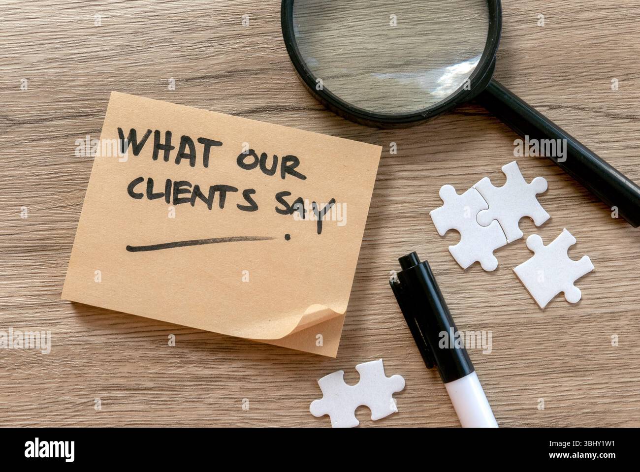 Concept de témoignages de clients avec loupe, pièces de puzzle et Note sur le bureau en bois Banque D'Images