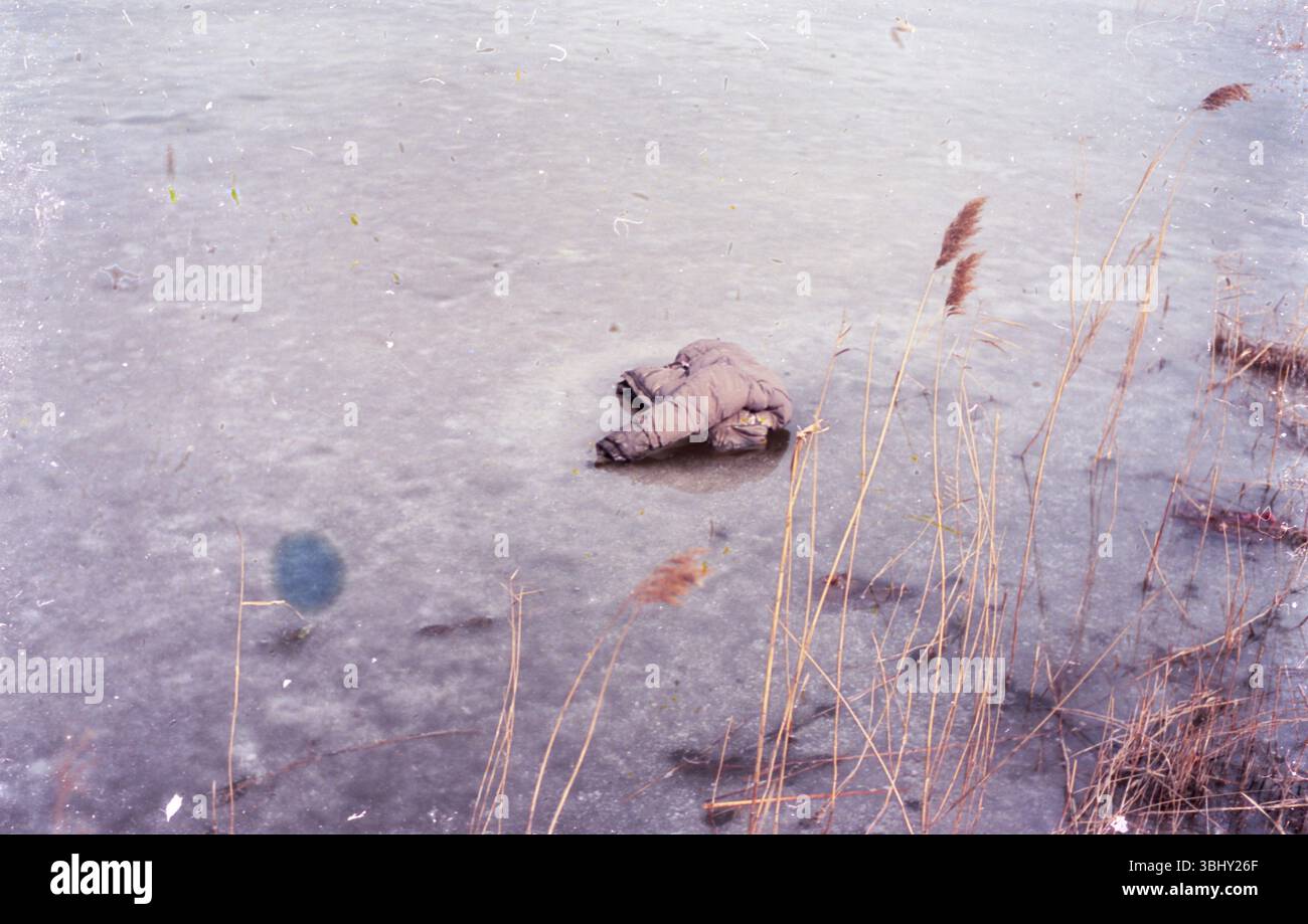 Manteau abandonné gelé sur un lac d'hiver Banque D'Images