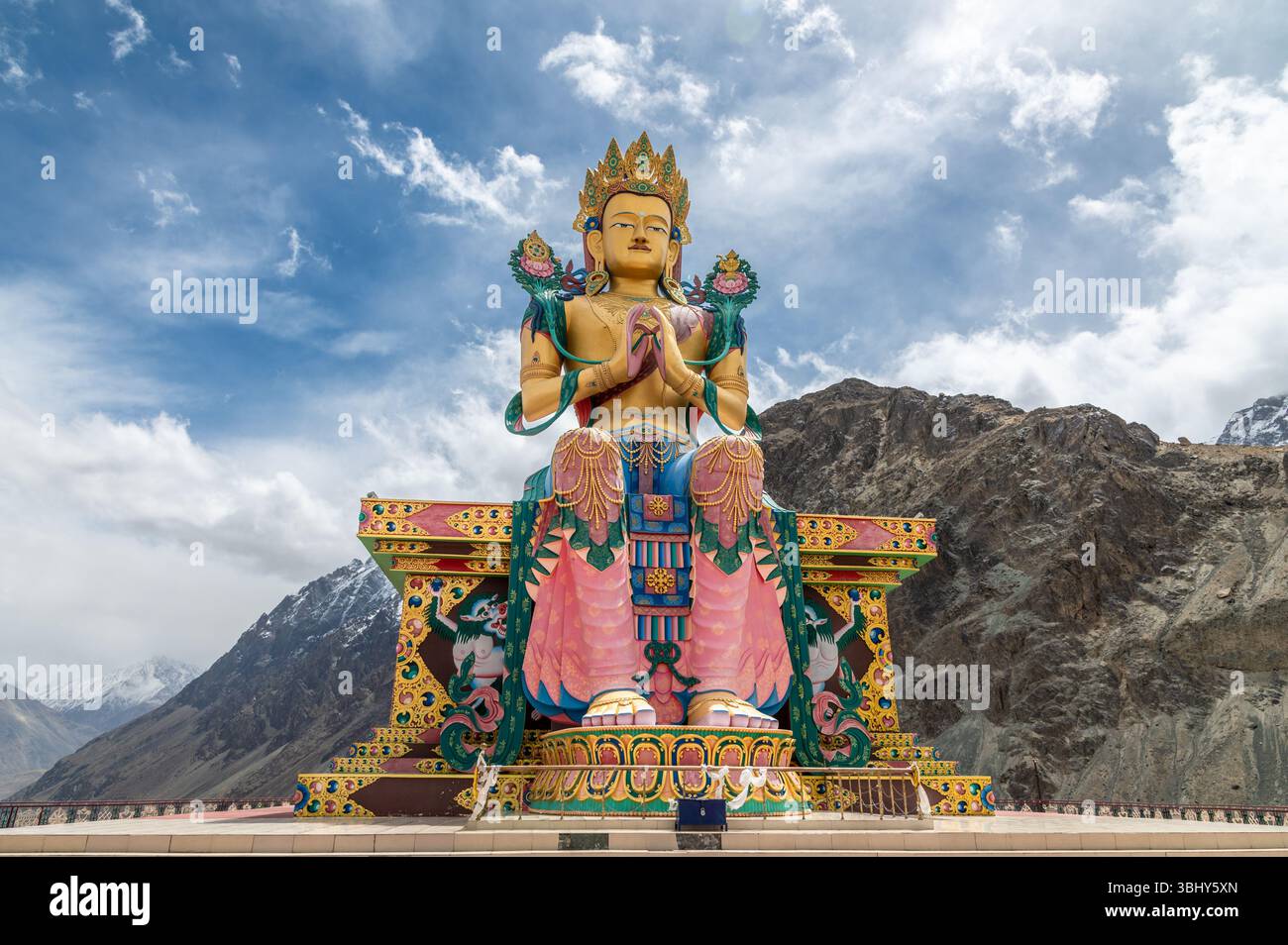 Majestueuse statue de Bouddha Maitreya au monastère Diskit, Ladakh, avec des sommets enneigés de l'Himalaya en arrière-plan, symbole de paix, de foi et de culture. Banque D'Images