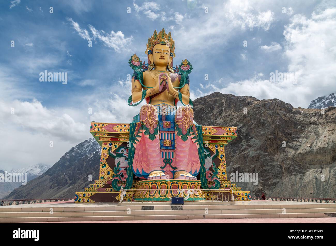 Majestueuse statue de Bouddha Maitreya au monastère Diskit, Ladakh, avec des sommets enneigés de l'Himalaya en arrière-plan, symbole de paix, de foi et de culture. Banque D'Images