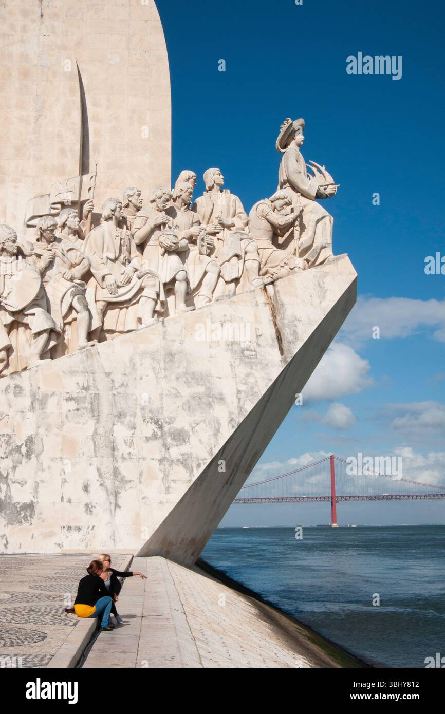 Lisbonne, Portugal - deux femmes touristes sont assises sur les marches sous la sculpture du Monument des découvertes à Belem. Banque D'Images