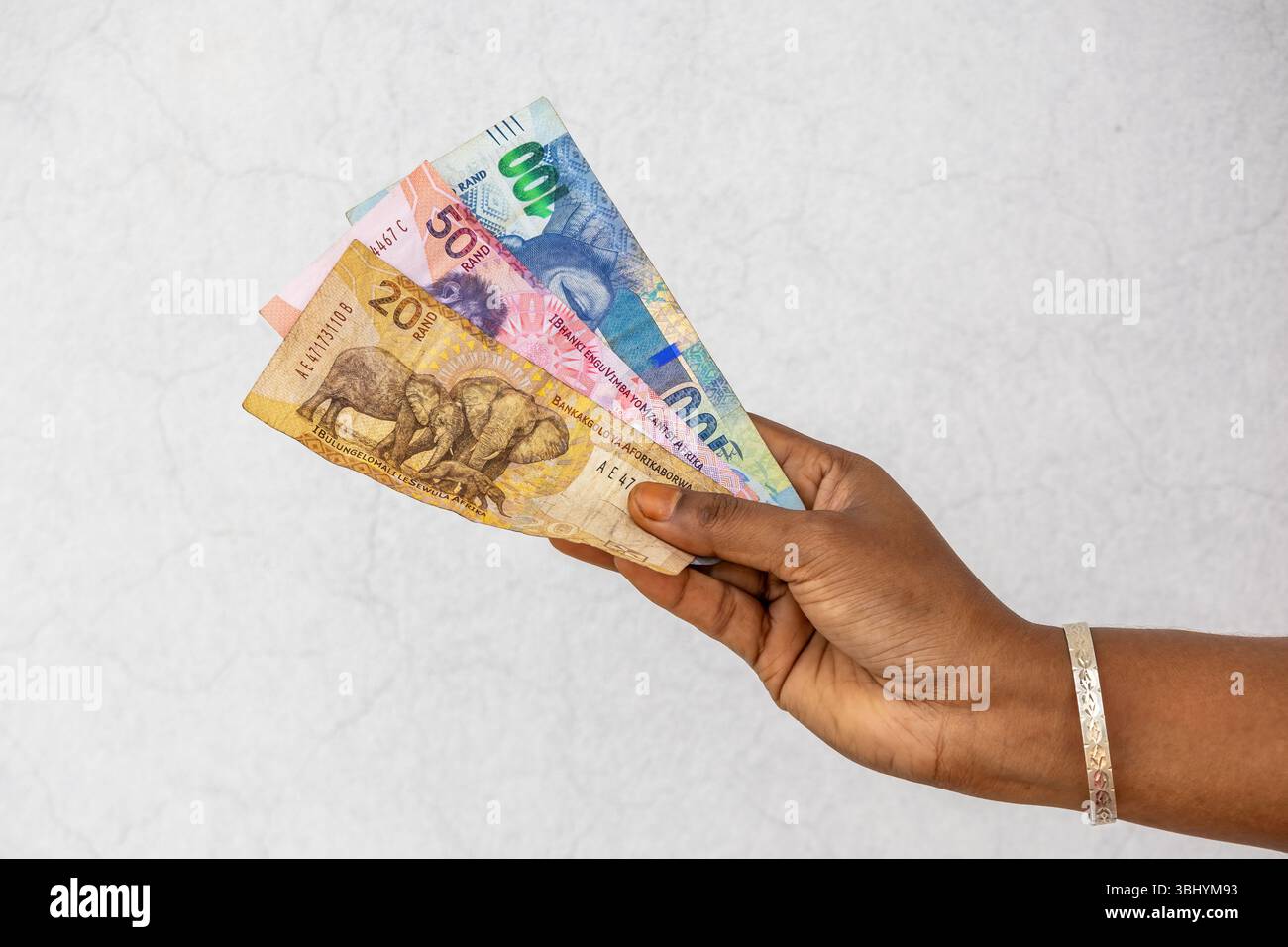 Main féminine tenant des billets de banque Rand sud-africains R20 R50 R100. Afrique du Sud argent concept financier. Banque D'Images