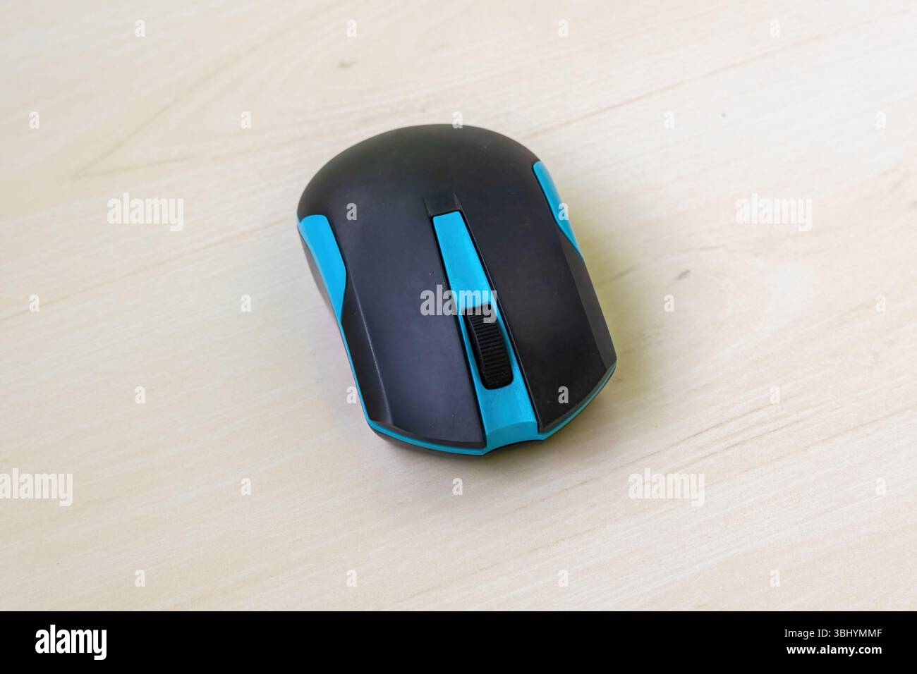 Souris d'ordinateur Bluetooth noire et bleue sur surface en bois. Conception sans câble pour une utilisation facile. Banque D'Images