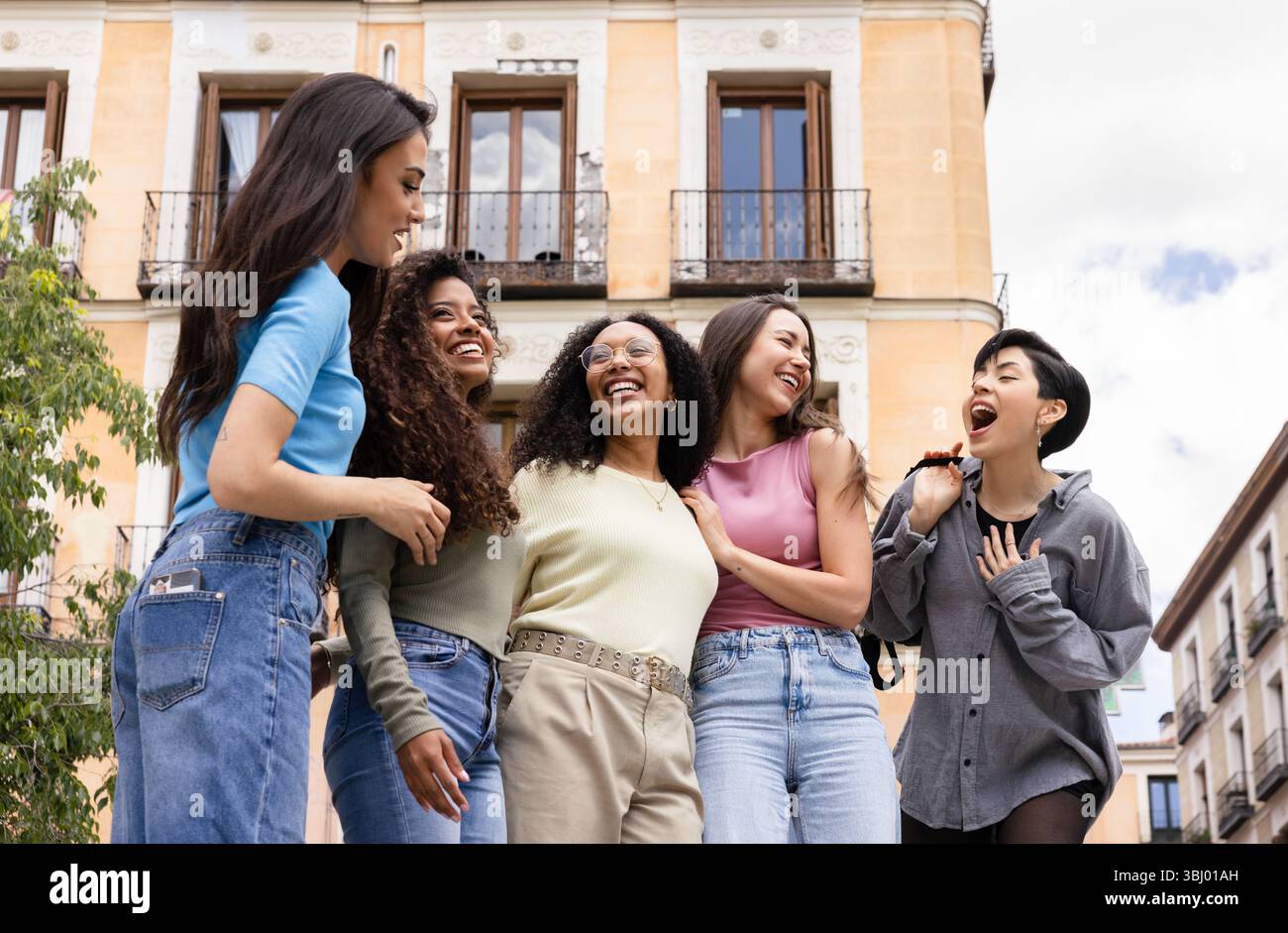 Un groupe diversifié de cinq amis riant et se liant à l'extérieur dans un contexte urbain, mettant en valeur l'amitié, le bonheur et la joie de dépenser qua Banque D'Images Un groupe diversifié de cinq amis riant et se liant à l'extérieur dans un contexte urbain, mettant en valeur l'amitié, le bonheur et la joie de dépenser qua Banque D'Images