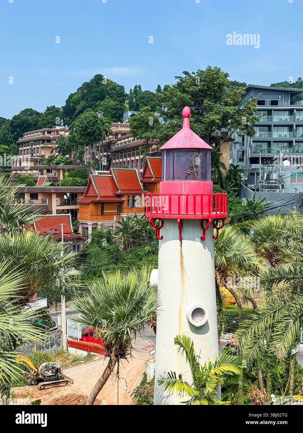 Un phare pittoresque se dresse au milieu d'une végétation luxuriante et d'une architecture tropicale à Phuket, en Thaïlande, capturant la beauté naturelle et vibrante de l'île Banque D'Images
