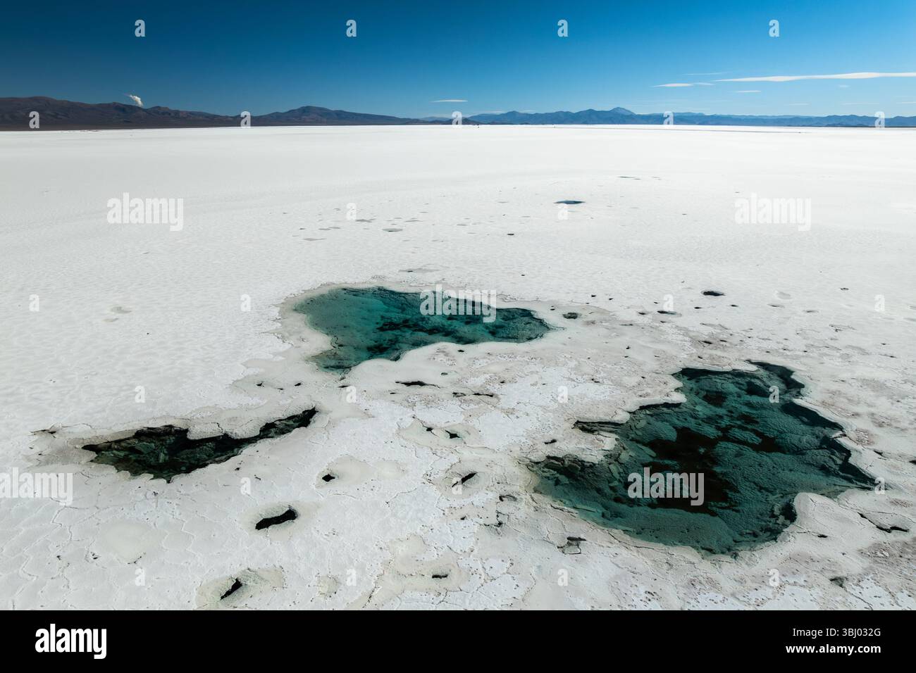 Une vue imprenable sur Salinas grandes à Salta, Argentine, présente de vastes étendues de sel blanc entrecoupées de bassins turquoise peu profonds sous un bl clair Banque D'Images