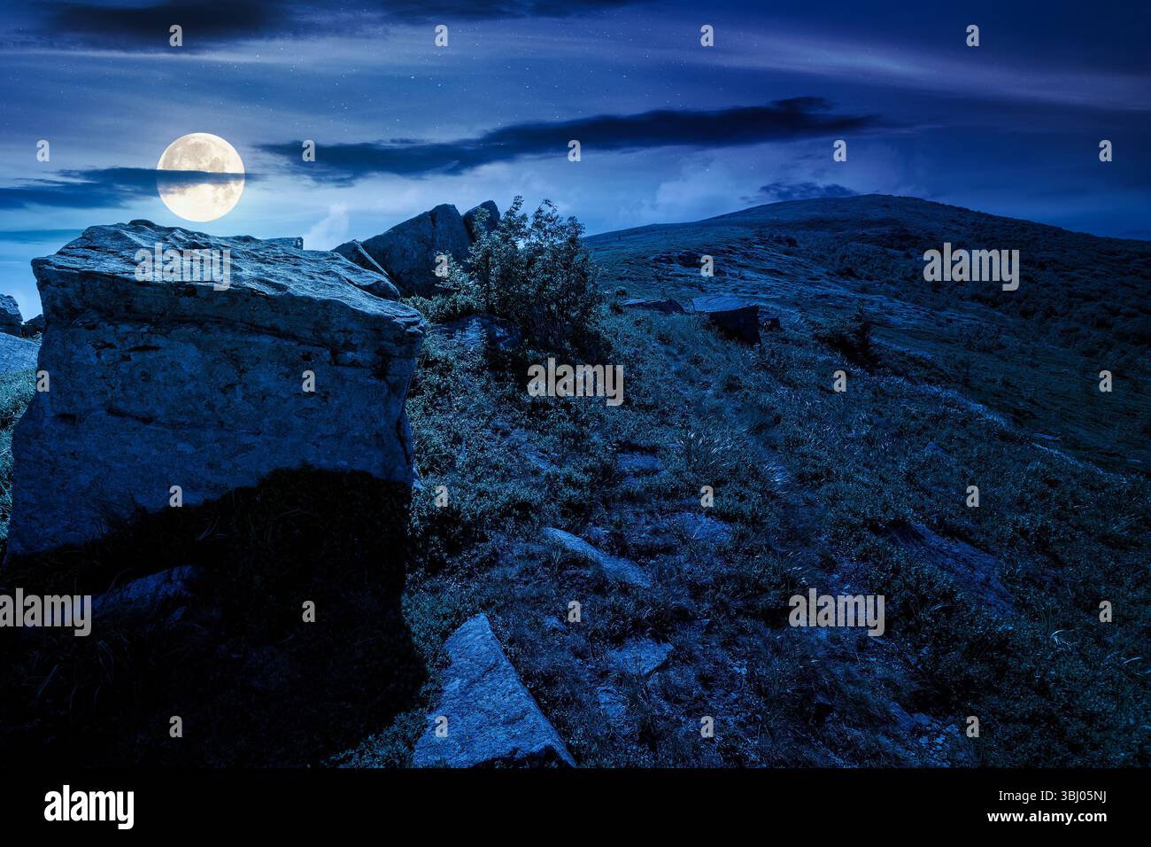boulder sur une colline sous le ciel bleu avec des nuages en été la nuit. énorme grès parmi l'herbe. chemin vers le sommet de la montagne en pleine lune Banque D'Images boulder sur une colline sous le ciel bleu avec des nuages en été la nuit. énorme grès parmi l'herbe. chemin vers le sommet de la montagne en pleine lune Banque D'Images