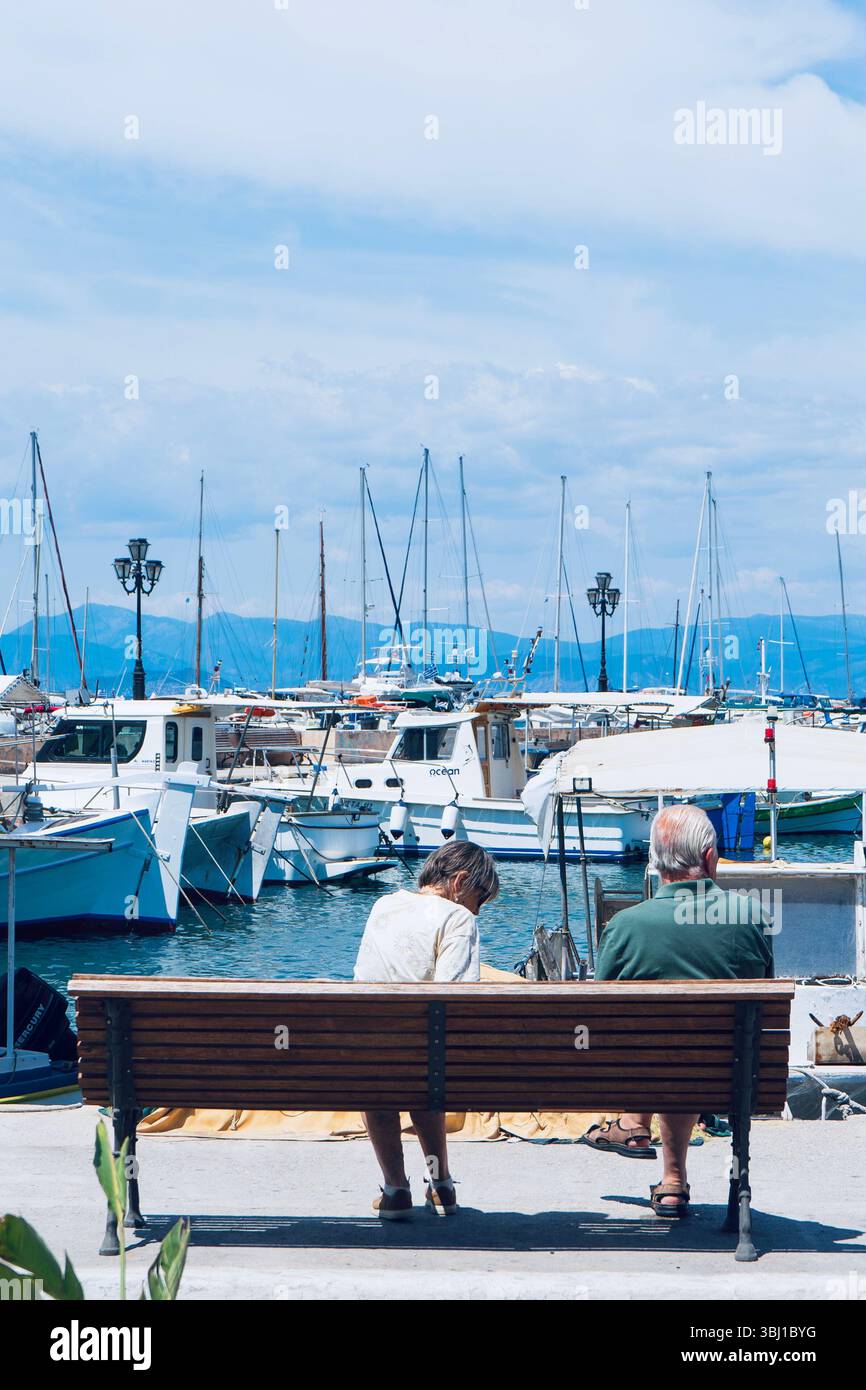 Coucher de soleil sur le port serein avec couple de personnes âgées relaxant Banque D'Images