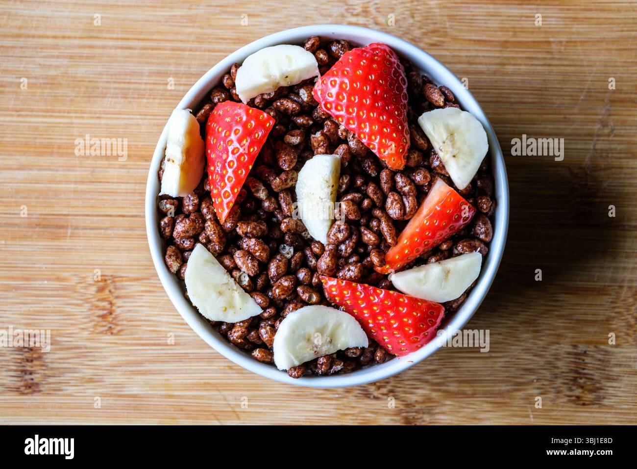Londres, Royaume-Uni, 12 juin 2025, bol de céréales pour petit-déjeuner Coco Pops classiques britanniques préférées avec fraises et bananes Banque D'Images