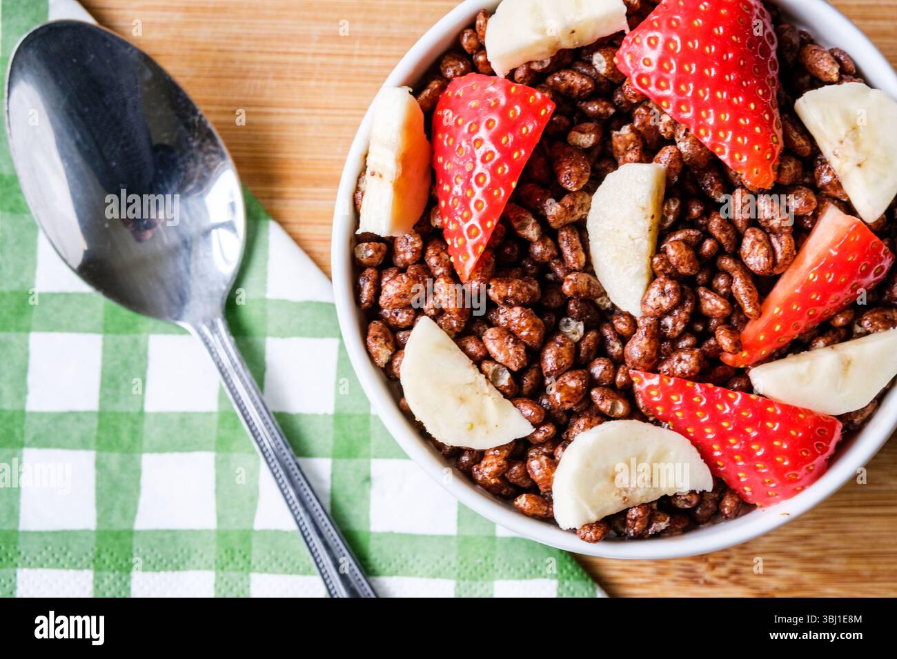 Londres, Royaume-Uni, 12 juin 2025, bol de céréales pour petit-déjeuner Coco Pops classiques britanniques préférées avec fraises et bananes Banque D'Images
