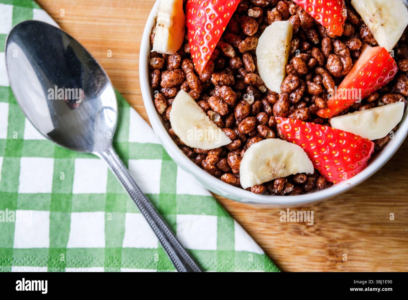 Londres, Royaume-Uni, 12 juin 2025, bol de céréales pour petit-déjeuner Coco Pops classiques britanniques préférées avec fraises et bananes Banque D'Images