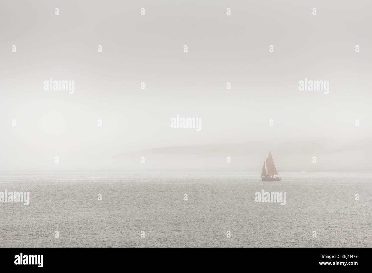 Un voilier navigue dans l'océan un jour brumeux. Le ciel est couvert et l'eau calme. Camaret sur mer, Crozon, Finistère, Bretagne, France Banque D'Images Un voilier navigue dans l'océan un jour brumeux. Le ciel est couvert et l'eau calme. Camaret sur mer, Crozon, Finistère, Bretagne, France Banque D'Images
