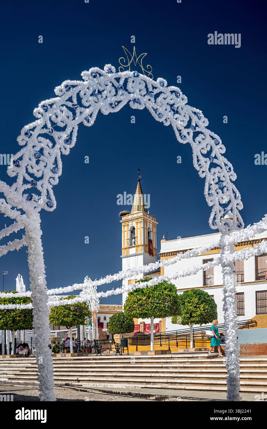 Des arcs en bois ornés de papier vibrant préparent la place pour les festivités honorant la Vierge du Rosaire à Carrión de los Céspedes. Banque D'Images