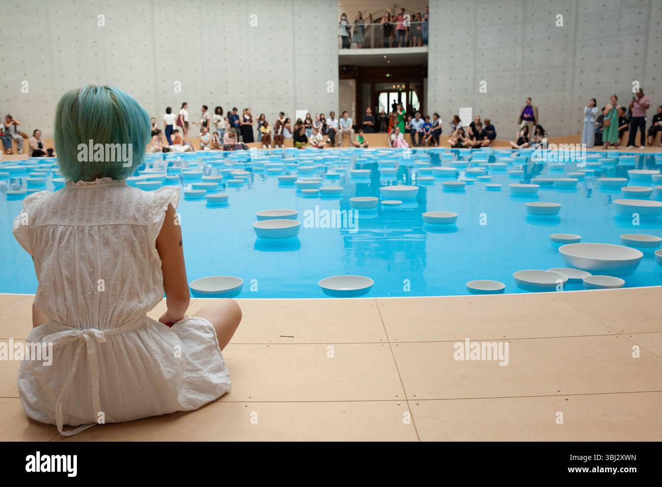 Paris, France. 12 juin 2025. Cet été, les visiteurs de la collection François Pinault de l'ancienne Bourse de commerce peuvent voir l'installation artistique 'clinamen' de l'artiste Celeste boursier-Mougenot. Il utilise des objets domestiques tels que ces bols en porcelaine, mais comme ils flottent autour de la piscine de 18m sous la rotonde, ils sonnent les uns contre les autres créant une expérience mélodieuse et reposante pour les yeux et les oreilles. Les visiteurs ont jusqu'au 21 septembre pour attraper l'installation. Crédit : Anna Watson/Alamy Live News Banque D'Images