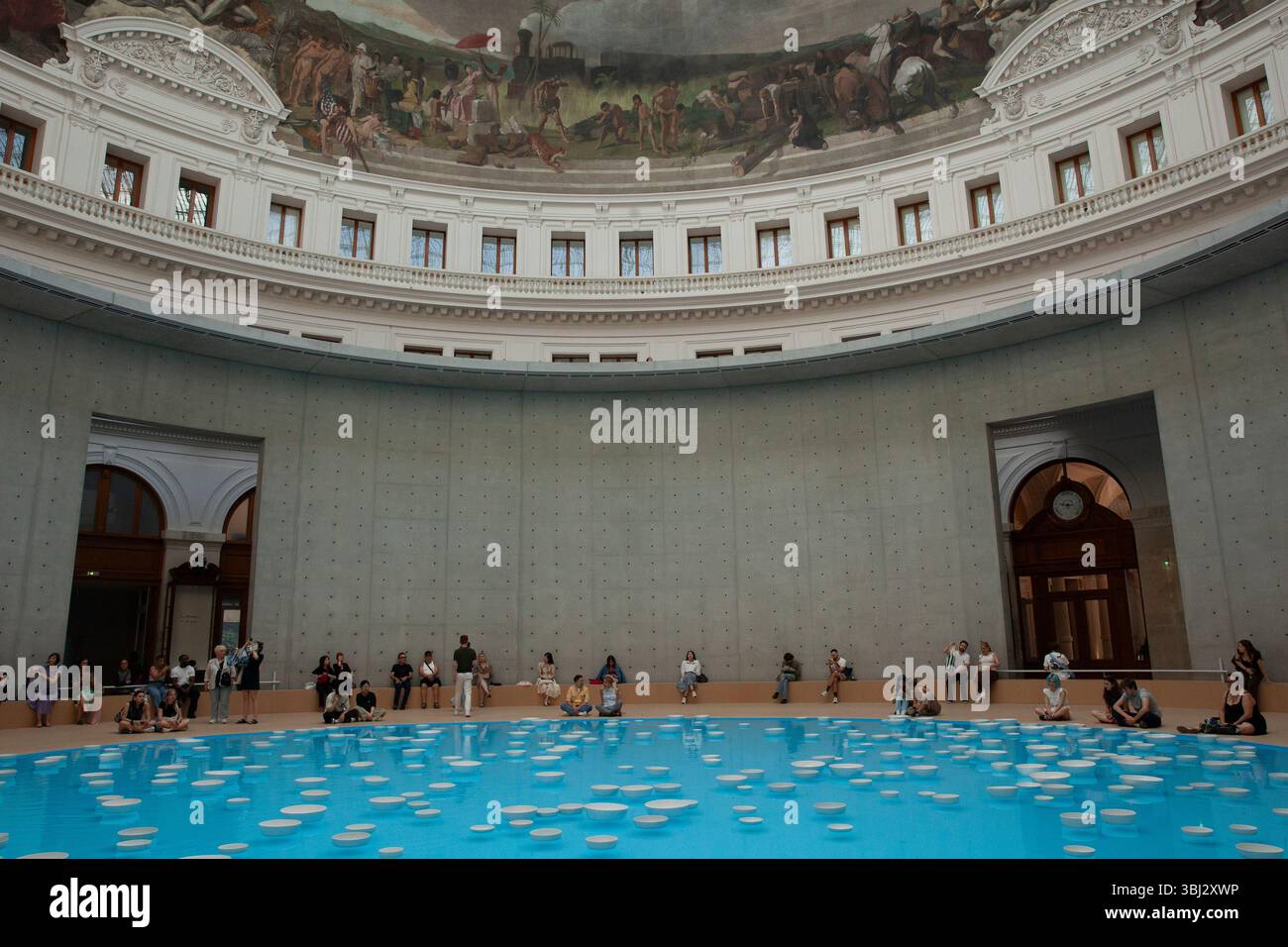 Paris, France. 12 juin 2025. Cet été, les visiteurs de la collection François Pinault de l'ancienne Bourse de commerce peuvent voir l'installation artistique 'clinamen' de l'artiste Celeste boursier-Mougenot. Il utilise des objets domestiques tels que ces bols en porcelaine, mais comme ils flottent autour de la piscine de 18m sous la rotonde, ils sonnent les uns contre les autres créant une expérience mélodieuse et reposante pour les yeux et les oreilles. Les visiteurs ont jusqu'au 21 septembre pour attraper l'installation. Crédit : Anna Watson/Alamy Live News Banque D'Images