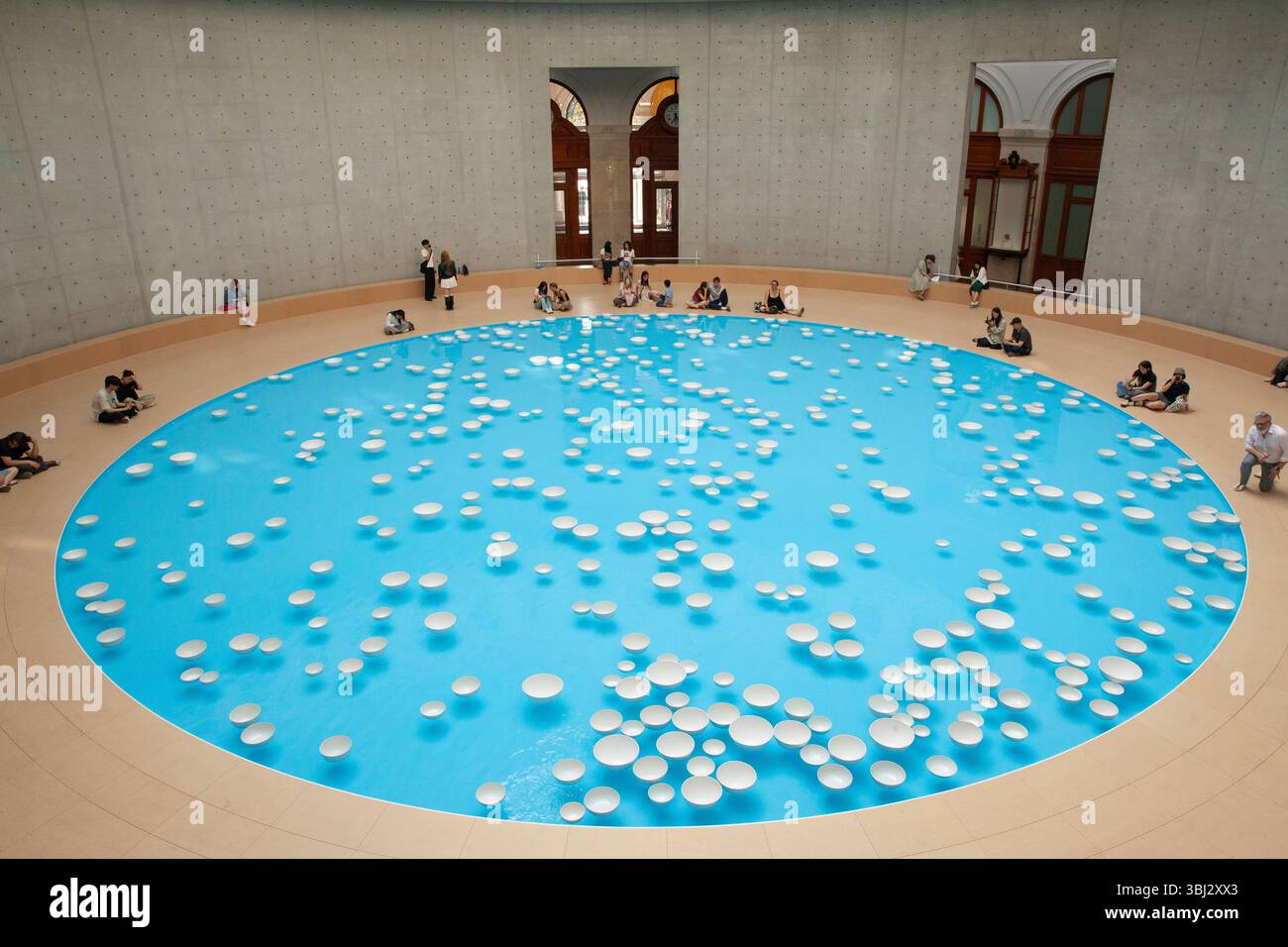 Paris, France. 12 juin 2025. Cet été, les visiteurs de la collection François Pinault de l'ancienne Bourse de commerce peuvent voir l'installation artistique 'clinamen' de l'artiste Celeste boursier-Mougenot. Il utilise des objets domestiques tels que ces bols en porcelaine, mais comme ils flottent autour de la piscine de 18m sous la rotonde, ils sonnent les uns contre les autres créant une expérience mélodieuse et reposante pour les yeux et les oreilles. Les visiteurs ont jusqu'au 21 septembre pour attraper l'installation. Crédit : Anna Watson/Alamy Live News Banque D'Images